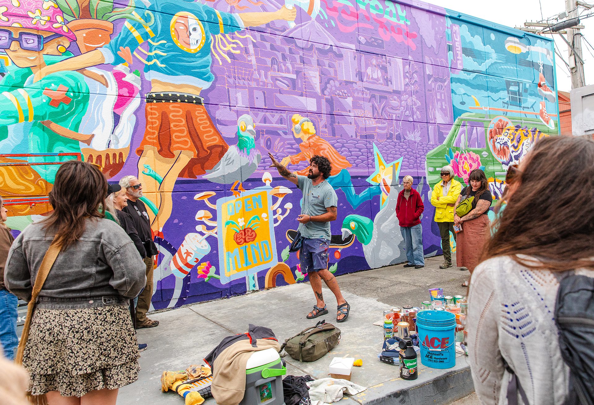 Artist explaining wall mural to onlookers