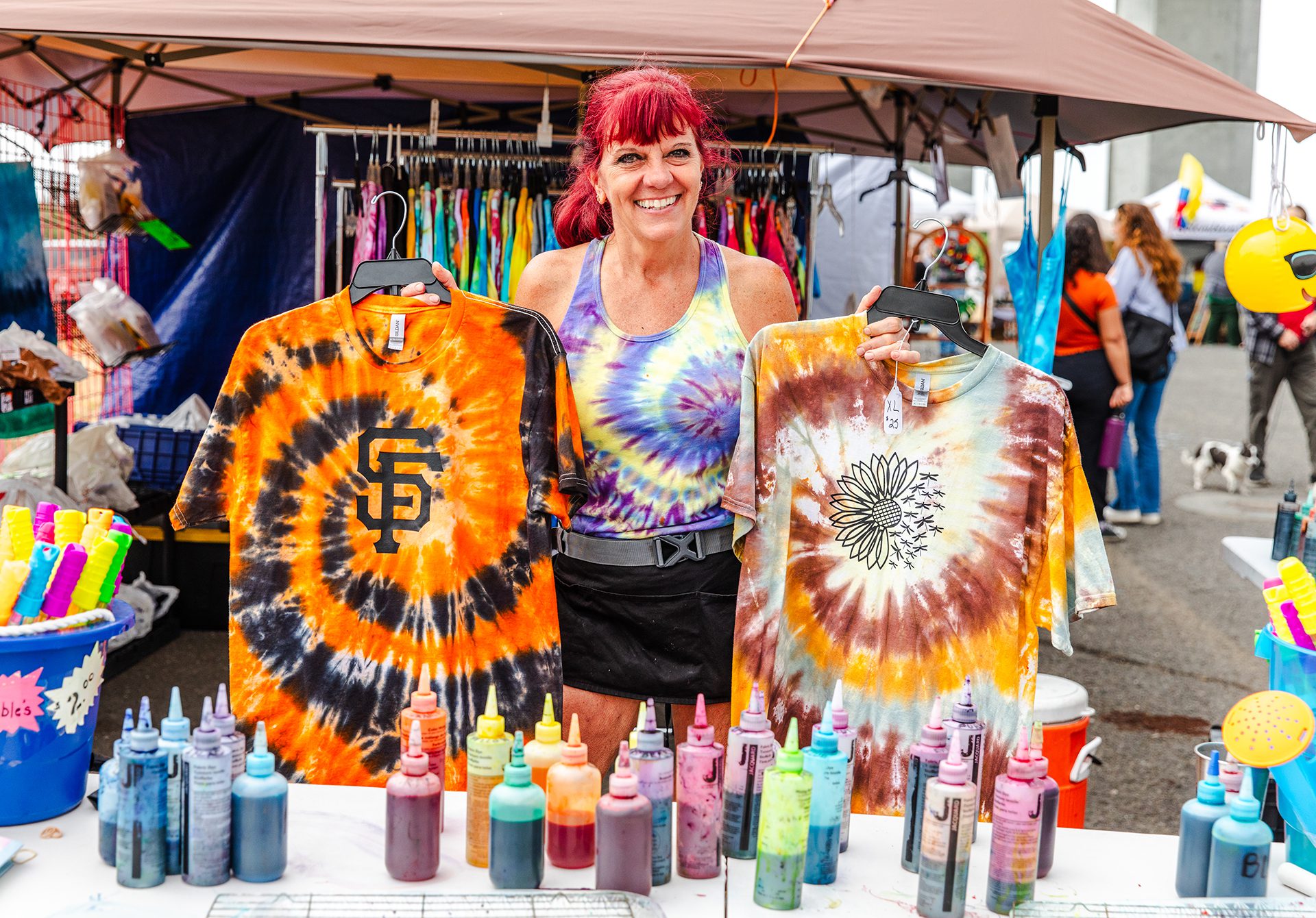 Woman holding up custom made tie dye shirts