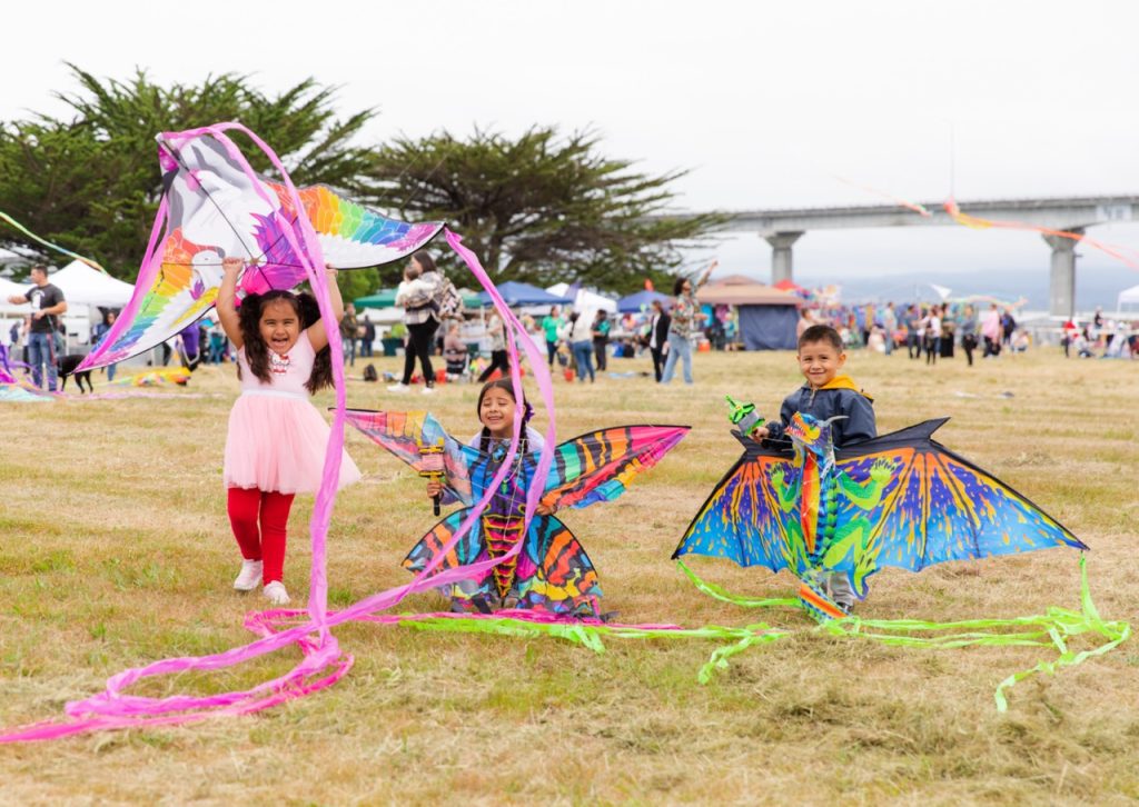 Young children holding kites during a festival