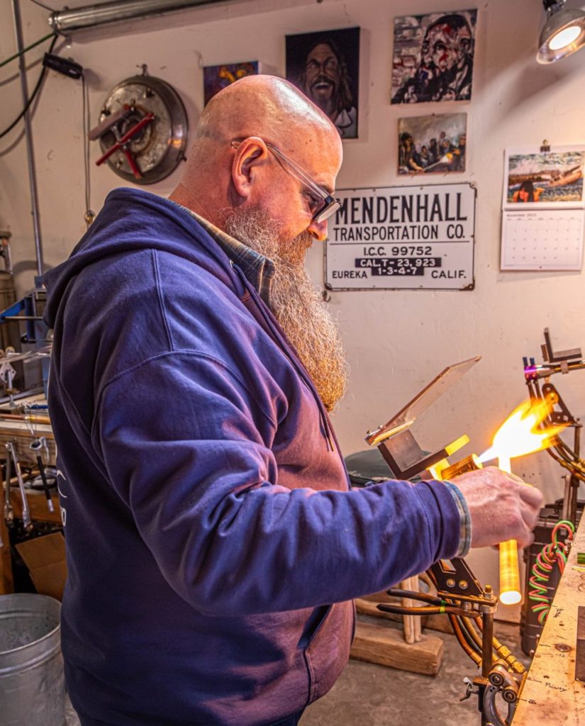 Topher Reynolds working with glass marbles in his studio. Photo by Alan Workman